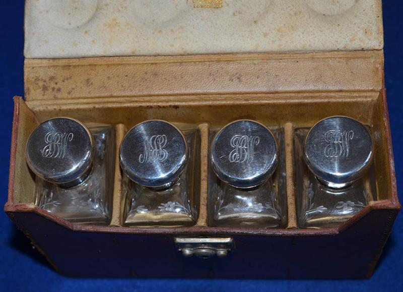 CASED SET OF FOUR ENGLISH SILVER AND GLASS SCENT BOTTLES.