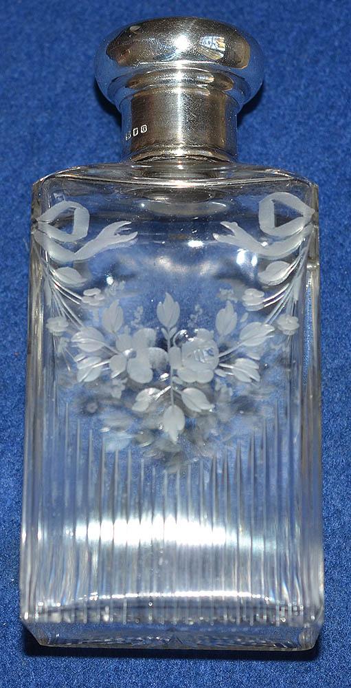 CASED SET OF FOUR ENGLISH SILVER AND GLASS SCENT BOTTLES.